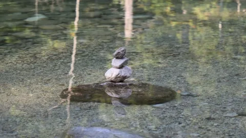 Balanced Rock Zen Stack in water of lake Stockbeeldmateriaal 138376903