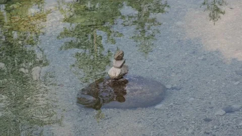 Balanced Rock Zen Stack in water of lake Stock Footage 138380046