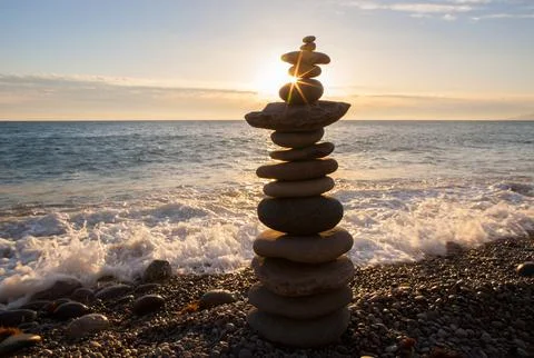 Balanced Stone Cairn on a Beach at Sunset Fotos Stock