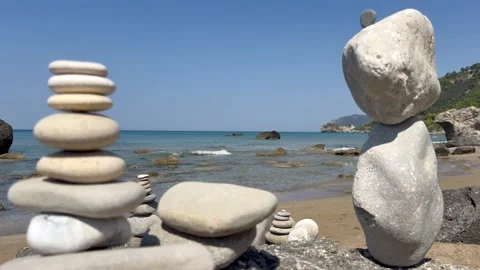 Balanced stone cairns on seaside rocks. The video represents concepts of balance Stock Footage 346540370