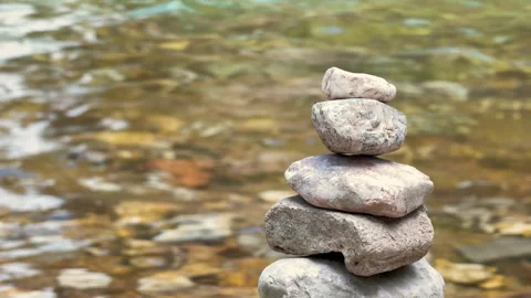 Balanced stone stack by a flowing river 動画素材 343139511