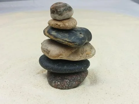 Balanced stone stack on sand Stock Photos