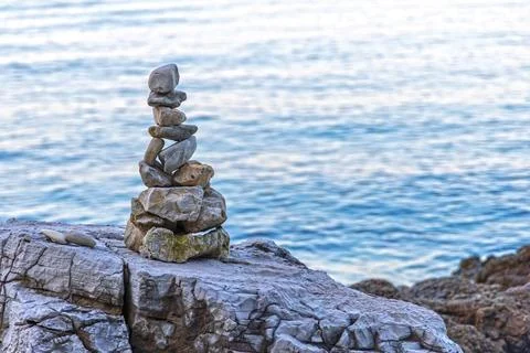 Balanced stone stack by the sea. Zen-inspired stack of balanced stones on a Stock Photos