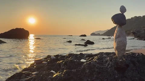 Balanced stone stack at sunset on Agios Gordios beach in Corfu, Greece. The vide Stock Footage 344426617
