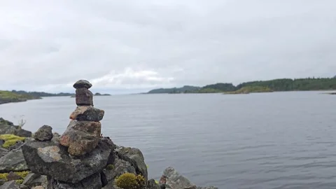 Balanced stone tower on granite rocks with ocean waves Stock Footage 341355562