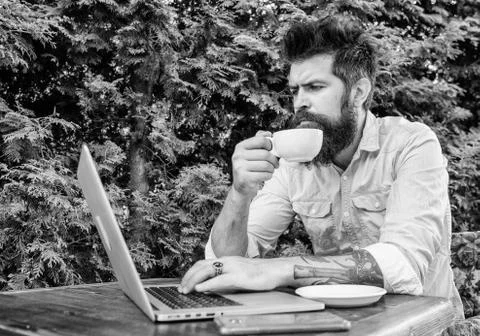 Balancing between work and pleasure. Hipster drinking tea and using computer Stock Photos