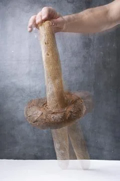 Balancing bread on a table on a gray background Foto stock