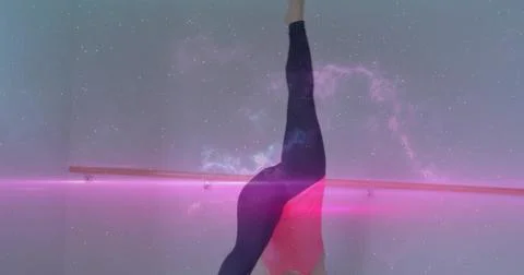 Balancing dancer in handstand in studio, pink leotard with barre, magenta streak Stock Photos