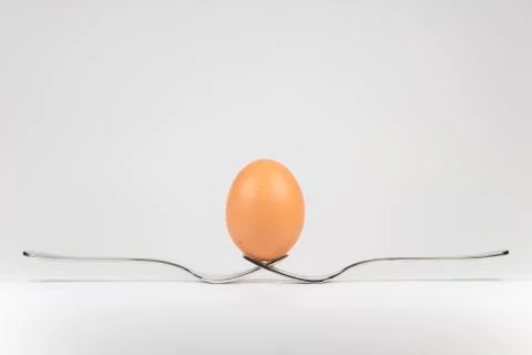 Balancing egg on two forks. Stock Photos