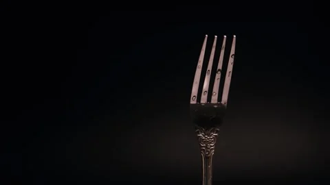 Balancing a fork on the tines in a dimly lit studio during the evening hours. Stock Footage 291956566