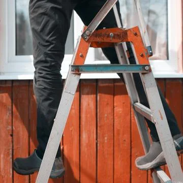 Balancing on a ladder 库存照片