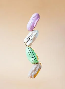 Balancing multicolored eclair cakes Stock Photos