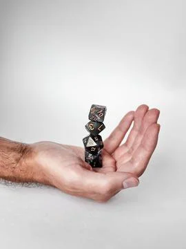 Balancing polyhedral dice in hand: precision and gaming aesthetics Stock Photos