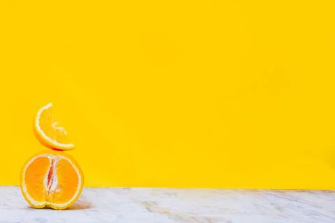 Balancing stack of fresh sliced oranges. Yellow background. Summer concept. C Stock Photos