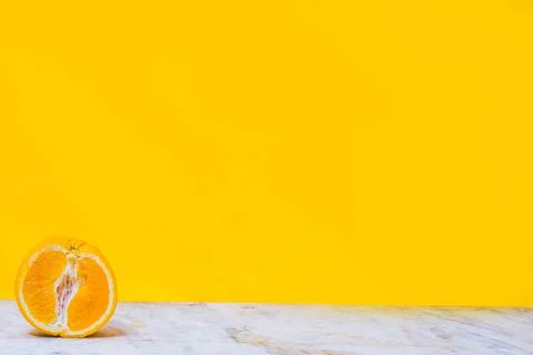 Balancing stack of fresh sliced oranges. Yellow background. Summer concept. C Stock Photos