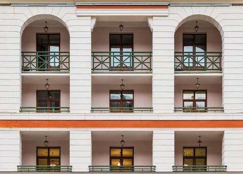 Balconies and windows in row on facade of urban building Stock Photos