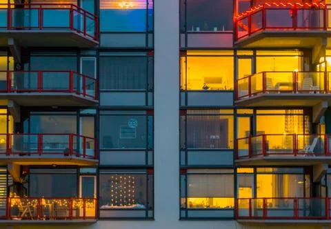 Balconies with lighted windows, Apartment complex at night, typical dutch arc Stock Photos