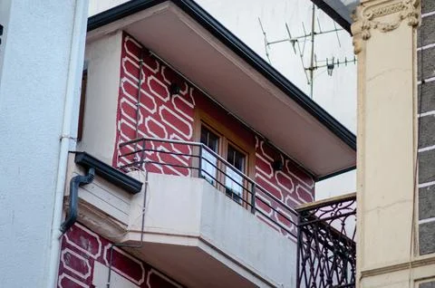 Balcony with Geometric Red Wall Pattern and Metal Railings on Urban Building Stock Photos