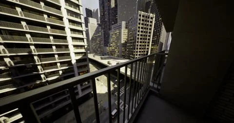Balcony view overlooking a bustling urban street with modern buildings Ilustración de archivo