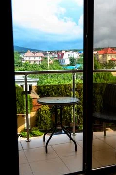 Balcony view with round table overlooking residential area and greenery Stock Photos