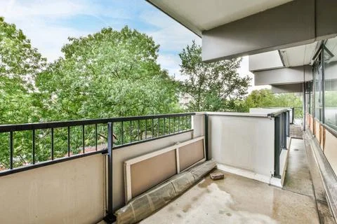 A balcony with a view of trees and a building Stock Photos