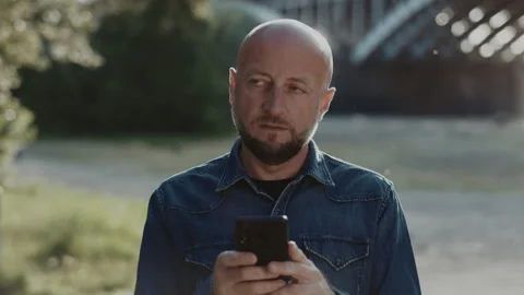 Bald and handsome man in his mid-forties with a stylish beard is standing in the Stock Footage 137177212
