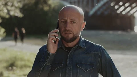 Bald and handsome man in his mid-forties with a stylish beard is standing in the Stock Footage 147594365