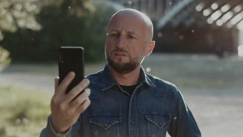 Bald and handsome manager with a stylish beard is standing in the park. He is Stock Footage 145060417