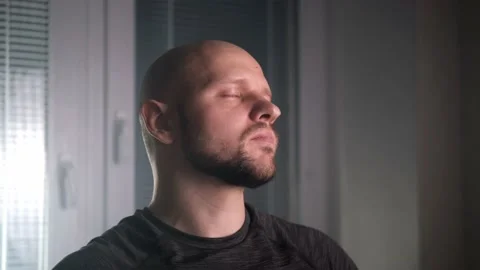 A bald athletic man drinks milk from a glass in the kitchen at home Stock Footage 168911173
