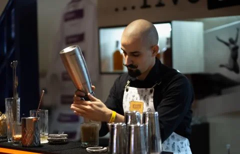 Bald barman with a twisted mustache preparing a cocktail Stock Photos