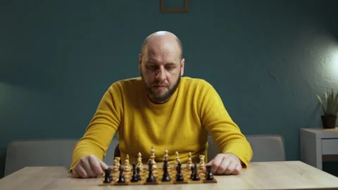 Bald bearded 40 year old man thoughtfully playing chess, brainstorming, strategy Stock Footage 278215893