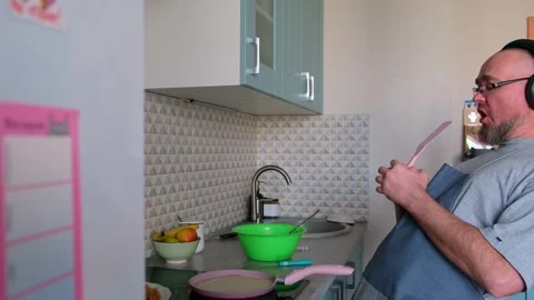 Bald bearded guy wearing apron having fun while baking pancakes on the stove. Stock Footage 270878432