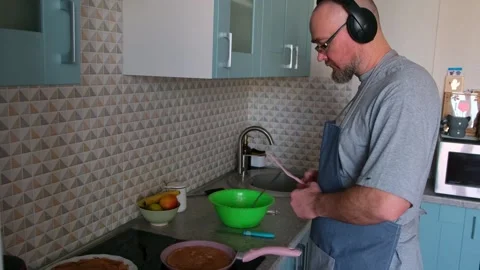 Bald bearded guy wearing apron having fun while baking pancakes on the stove. Stock Footage 271716243