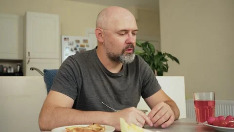 Bald bearded man sipping ramen broth from spoon. Focused eater leaning over bowl Video stock 324960467