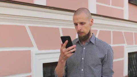 Bald bearded man using smart phone surfing social media Stock Footage 157992171