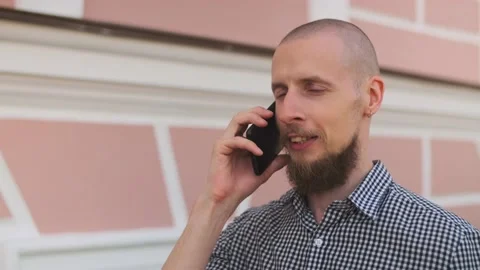 Bald bearded man using smart phone having a business conversation Stock Footage 157992203
