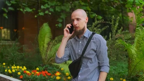 Bald bearded man using smart phone having a conversation Stock Footage 157992634