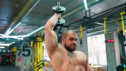 Bald bodybuilder exercising in the gym. Raises the barbell, dumbbells. Stock Footage 238778568