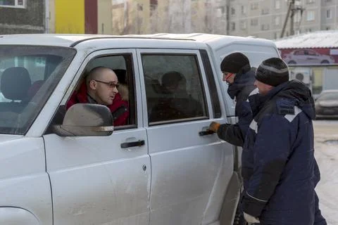 Bald boss in a red down jacket talking to a worker 写真素材
