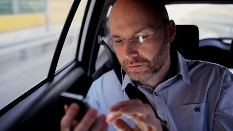 Bald Businessman in the Car Using His Mobile Phone Stock Footage 77573688