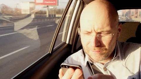 Bald Businessman Using a Mobile and Taking Glasses Off Stock Footage 74764779