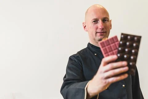 Bald caucasian middle aged chef dressed in black professional chef apron Stock Photos