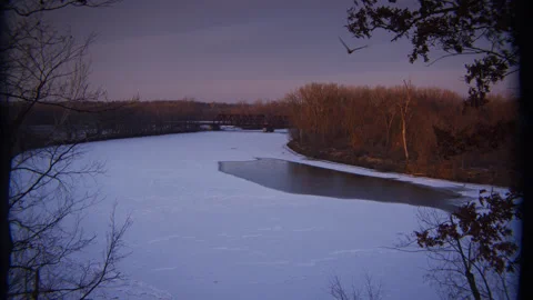 Bald Eagle takes flight across this panoramic scene of a frozen river at dusk. Stock Footage 233222196