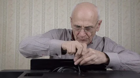 Bald engineer unscrews outdated black television set in room 库存影片 126761129