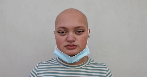 Bald girl posing in front of camera while wearing safety face mask Stock Footage 161066945