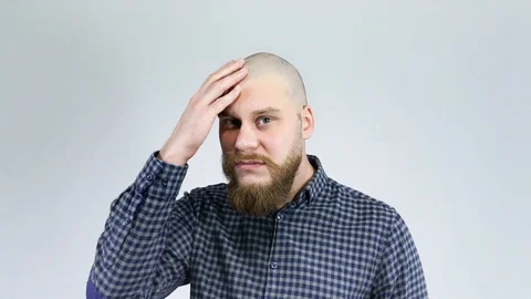 Bald guy with a beard sees itself in the mirror and crying. Stock Footage 122012508