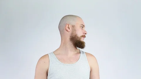 The bald guy with a beard, turns to camera and laughs. Stock Footage 121975435
