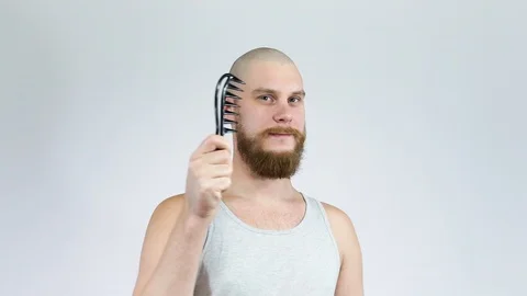 The bald guy with the bushy beard poses for the camera holding a comb Stock Footage 122005513