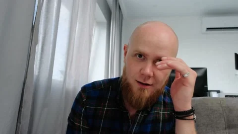 A bald guy with a red beard is surprised to tell a story in chat. Close-up. Stock Footage 139193651