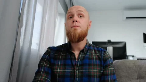 A bald guy shows a non-verbal sign of silence with his finger to his mouth. Stock Footage 139193907